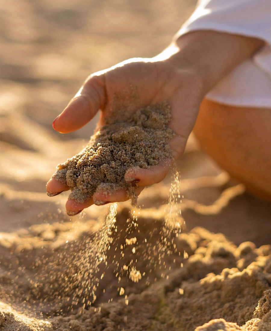 Close up of woman's hand with sand